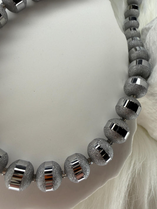 Silver beaded necklace on a white background