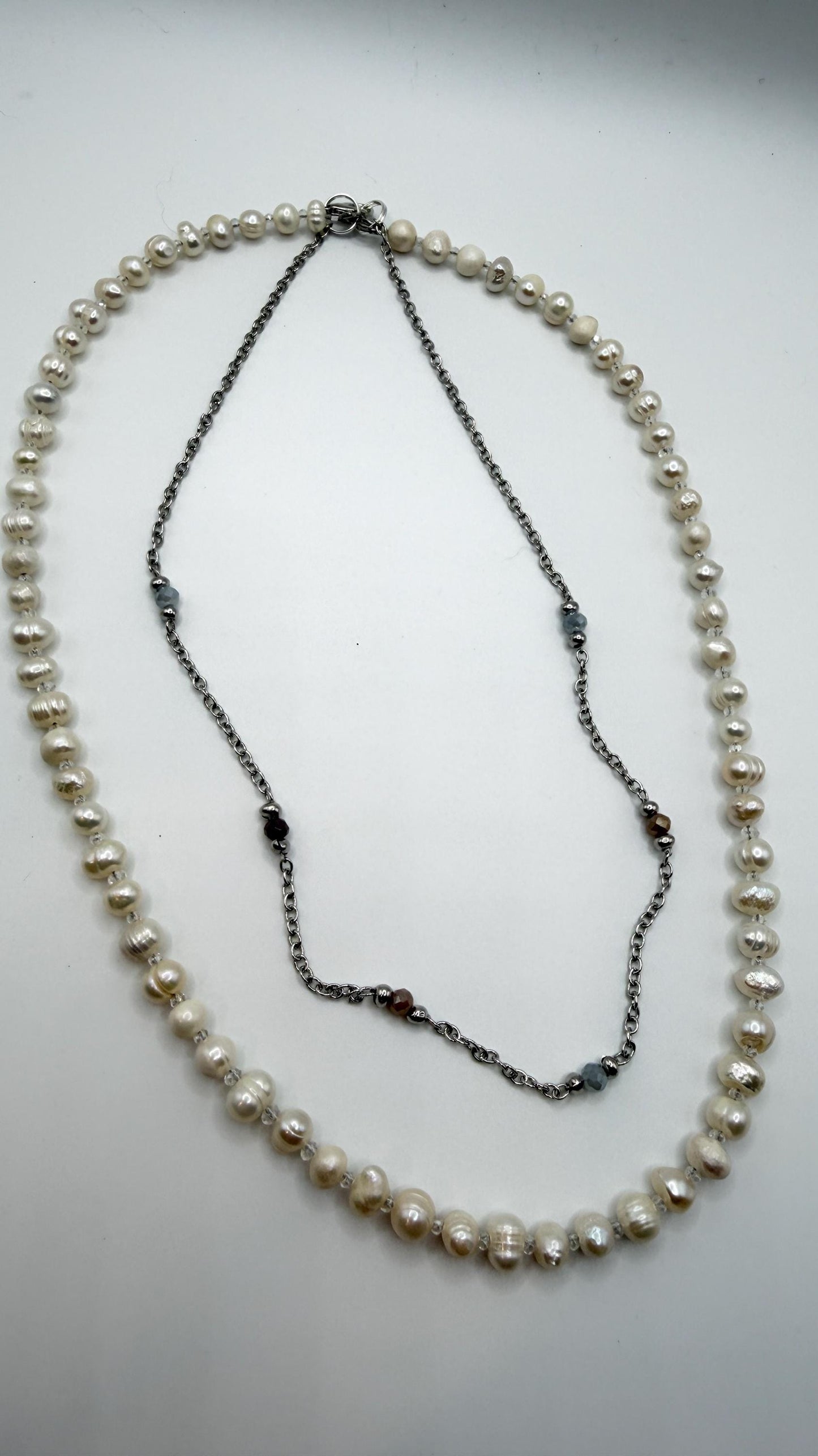 Pearl necklace with black beads on a light gray background