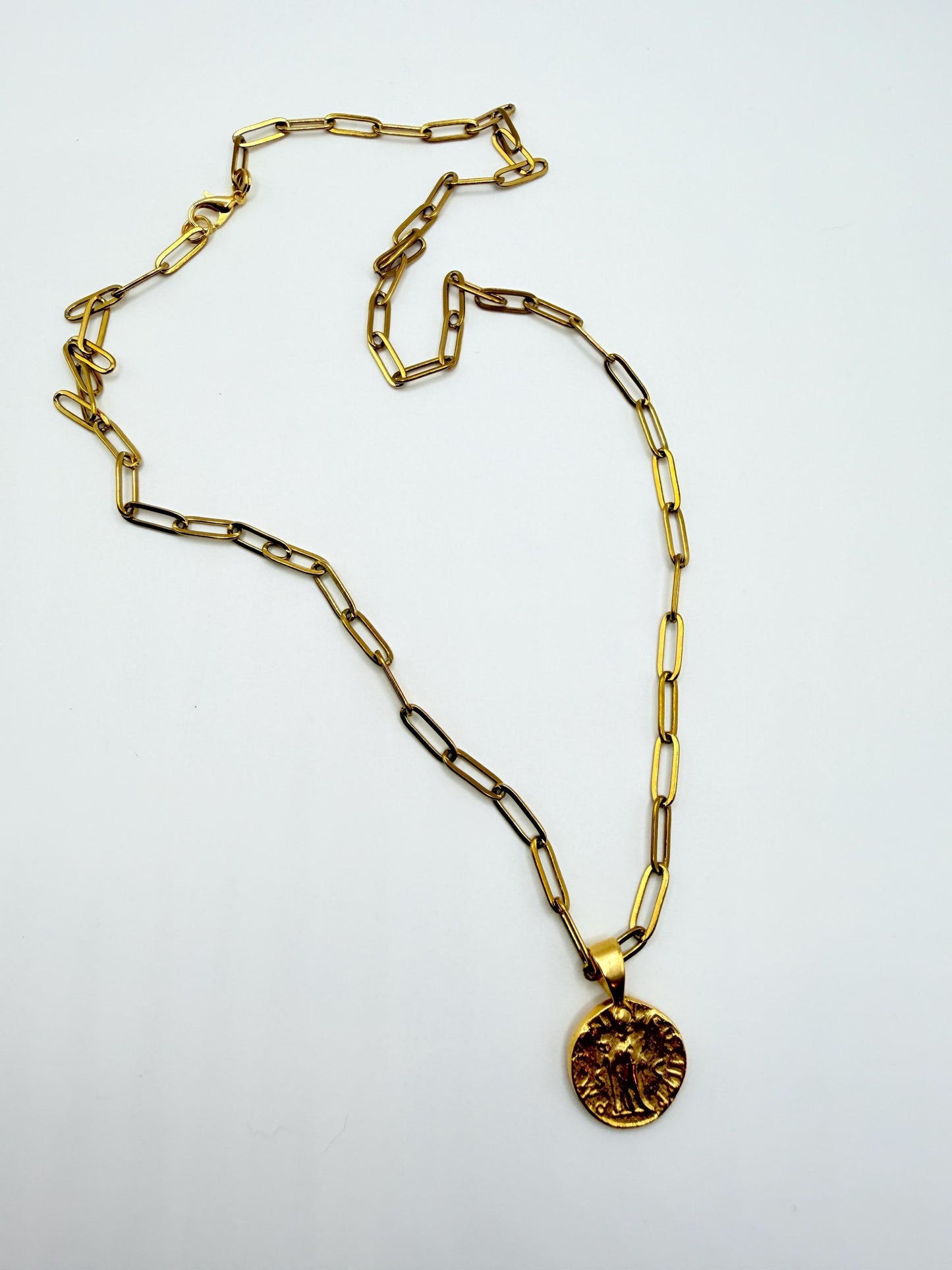 Gold chain necklace with a pendant on a white background
