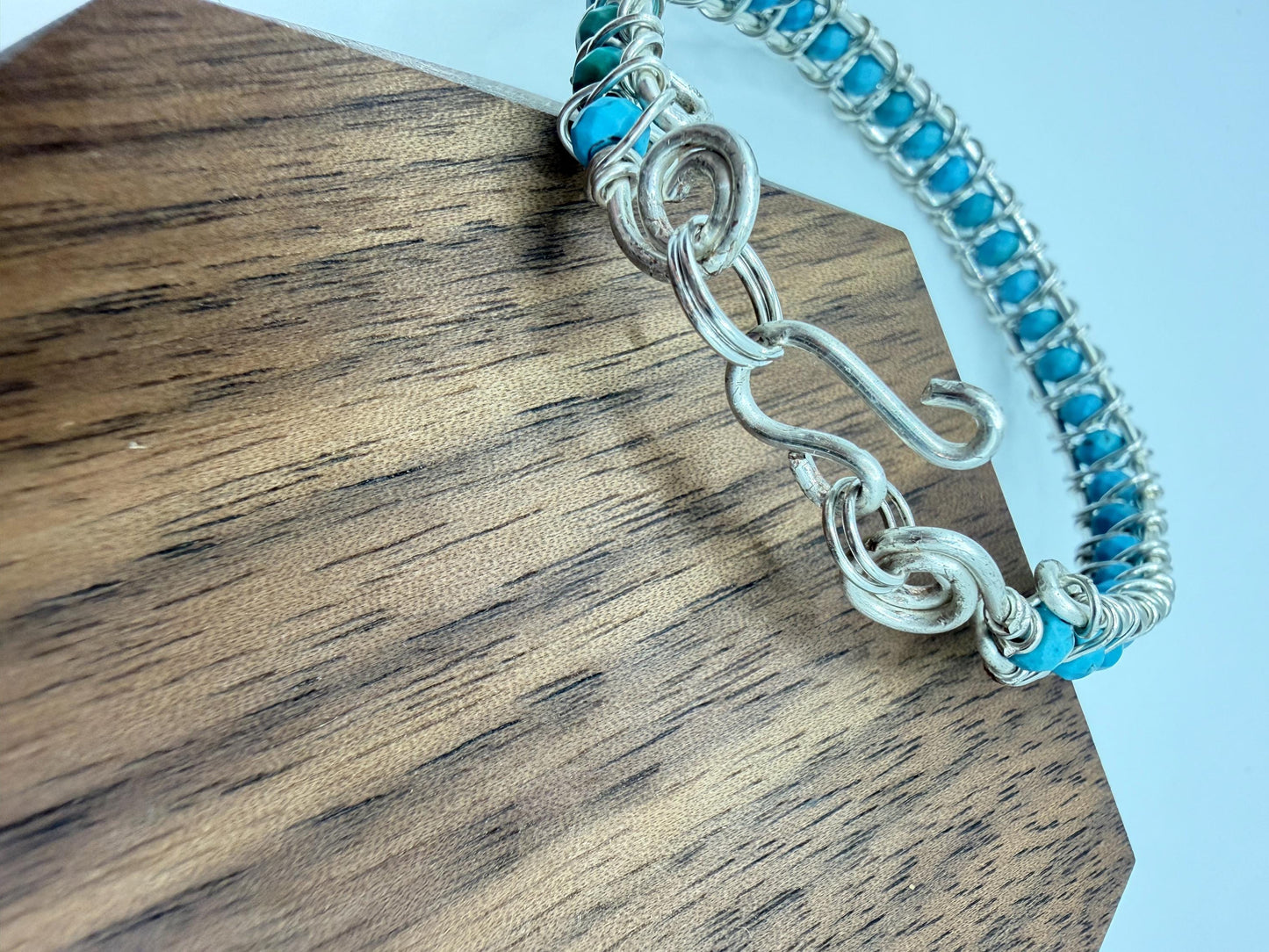 Silver bracelet with turquoise stones on a wooden surface
