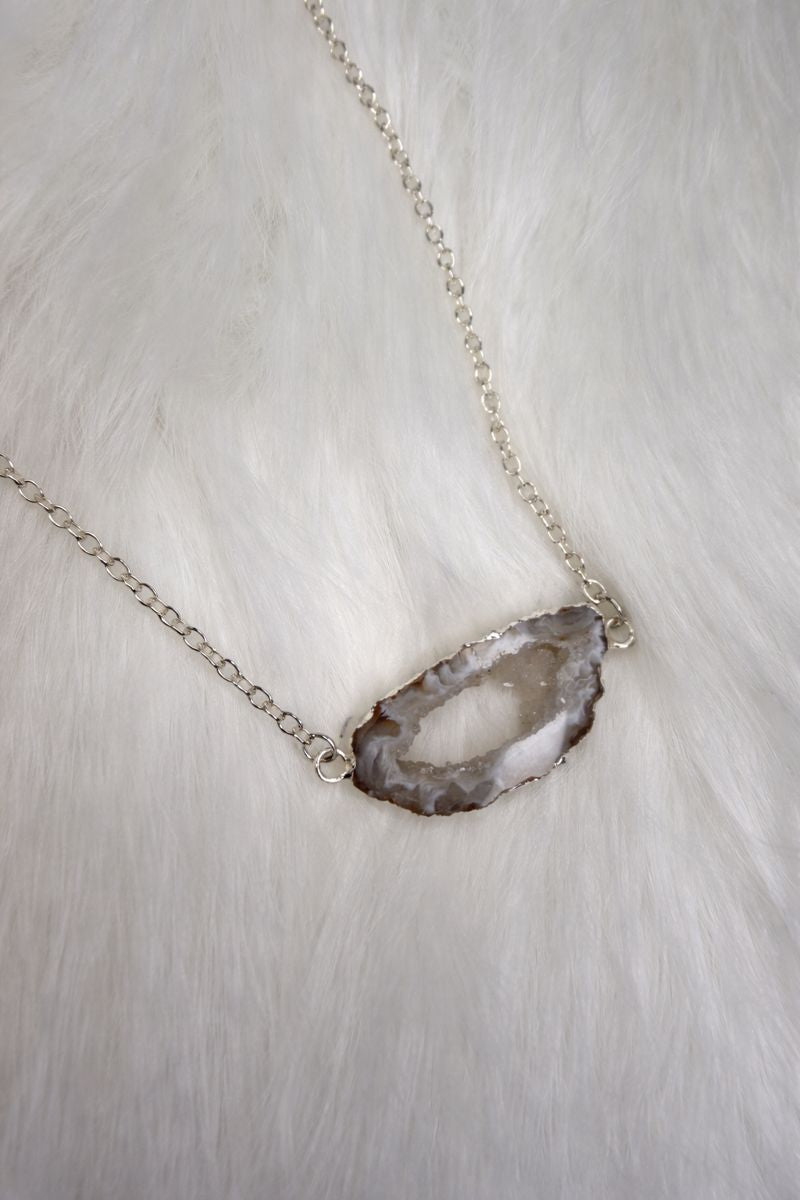 Necklace with a natural stone pendant on a light background