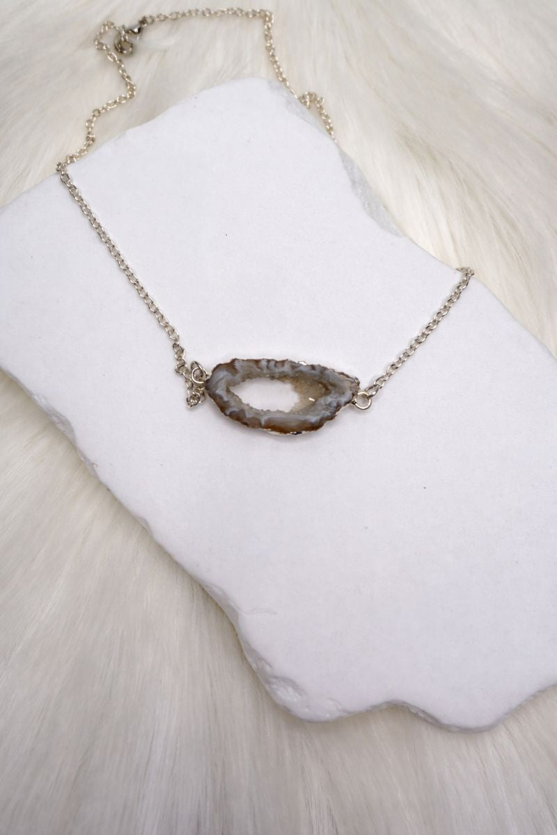 Necklace with a natural stone pendant on a white surface