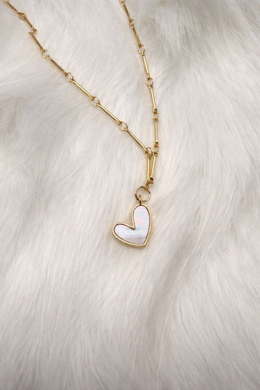 Necklace with a heart-shaped pendant on a white fur background