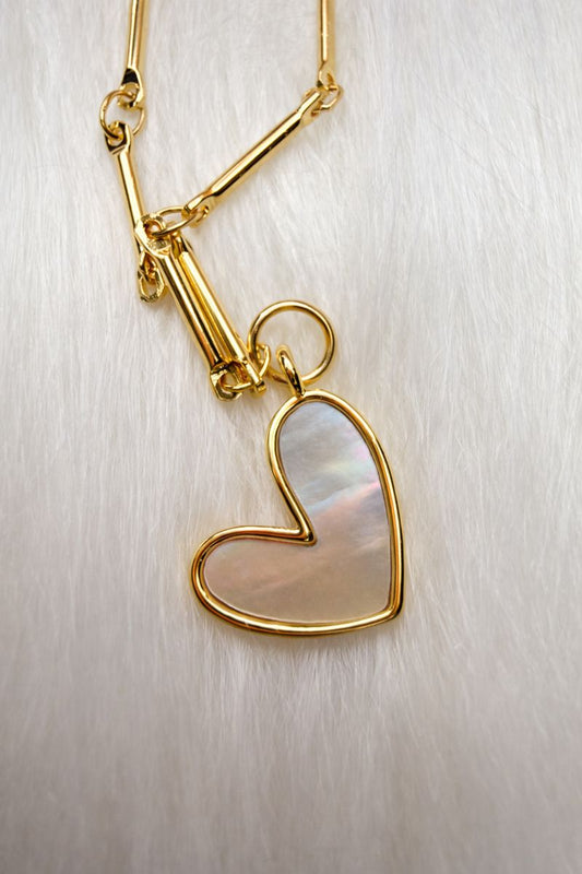 Gold heart-shaped pendant on a chain against a light background