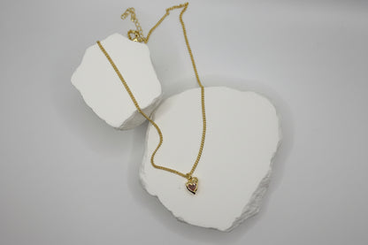 Gold necklace on a white stone surface