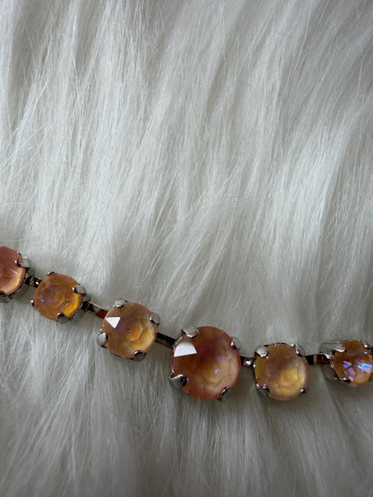 Necklace with peach colored aurora crystals on a fur background