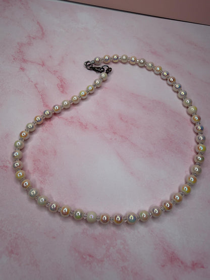 Pearl necklace on a pink marbled surface