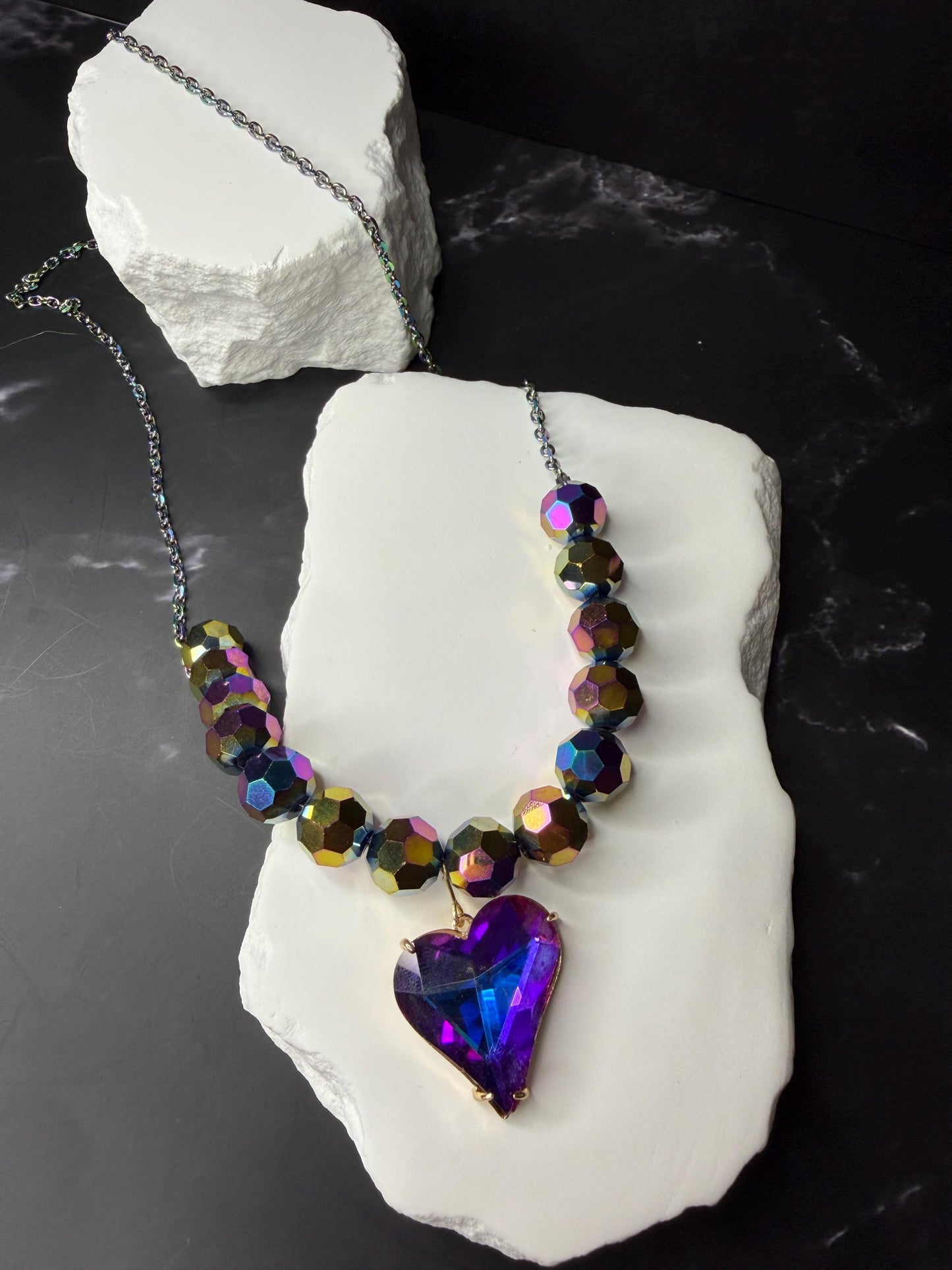 Necklace with heart-shaped pendant on a white stone block