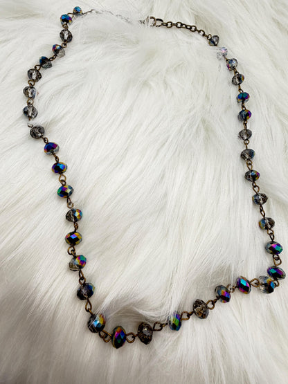 Necklace with multicolored beads on a white fur background