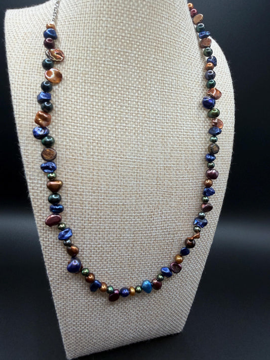 Multicolored pearl necklace on a white bust against a black background