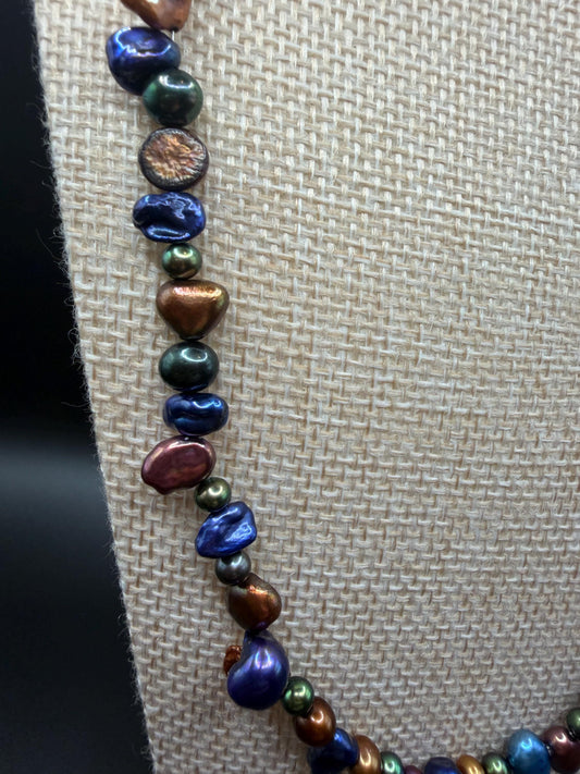 Necklace with multicolored pearls on a textured beige background