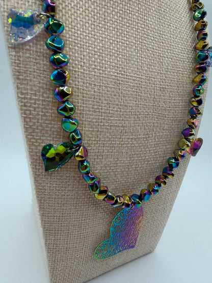 Necklace with colorful beads and a heart-shaped pendant on a beige stand.