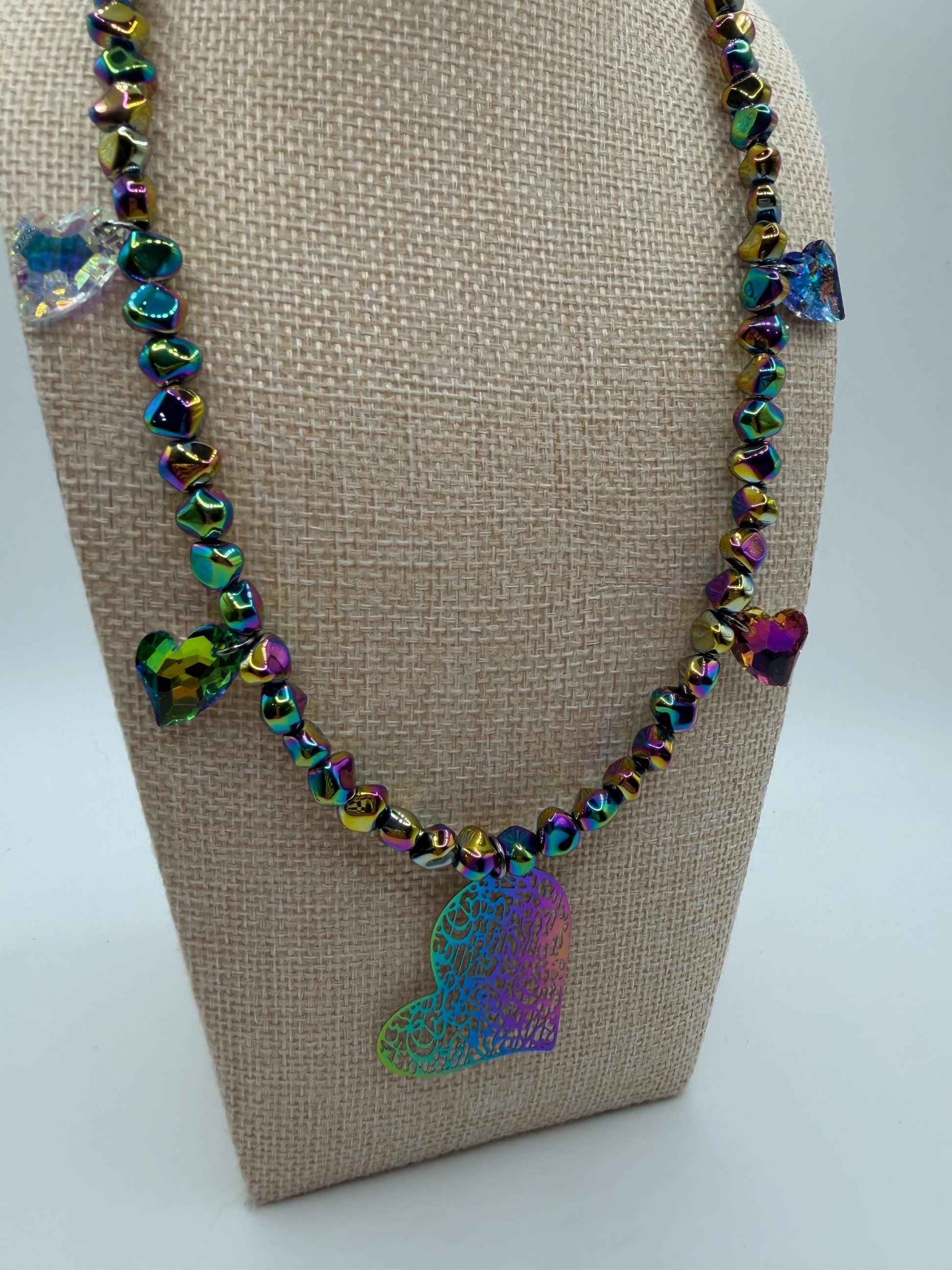 Necklace with colorful beads and butterfly pendants on a beige stand.