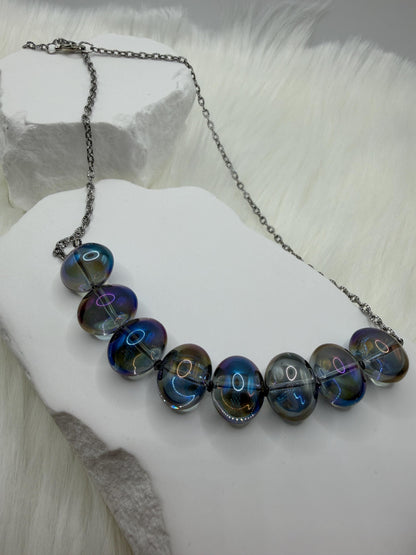 Necklace with blue and silver beads on a white surface
