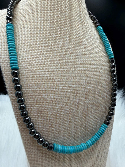 Necklace with turquoise and hematite beads on a mannequin bust.