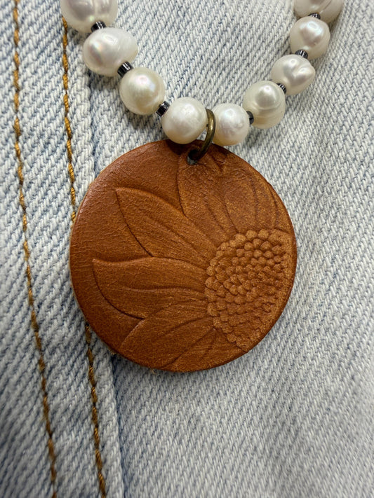 pearl Necklace with a brown leather pendant on a denim background