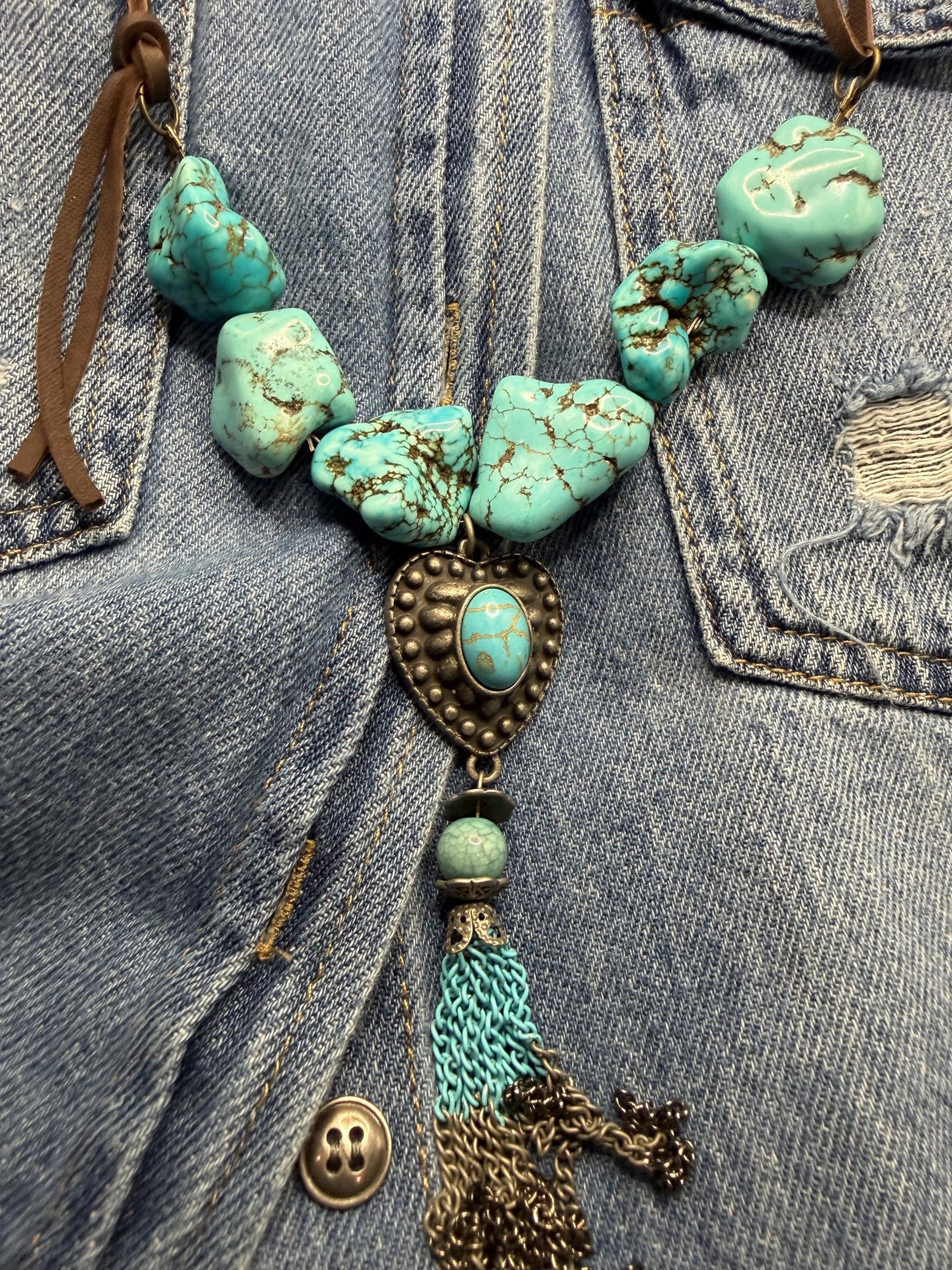 Turquoise beaded necklace with tassel on denim fabric