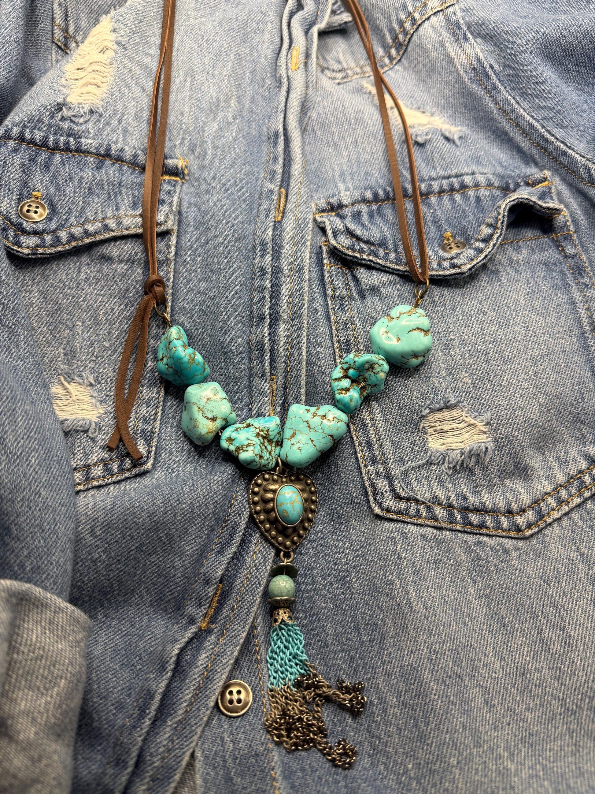 Turquoise beaded necklace with tassel on a denim jacket