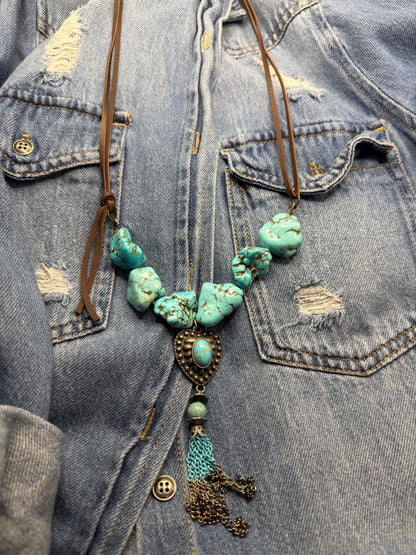 Turquoise beaded necklace with tassel on a denim jacket
