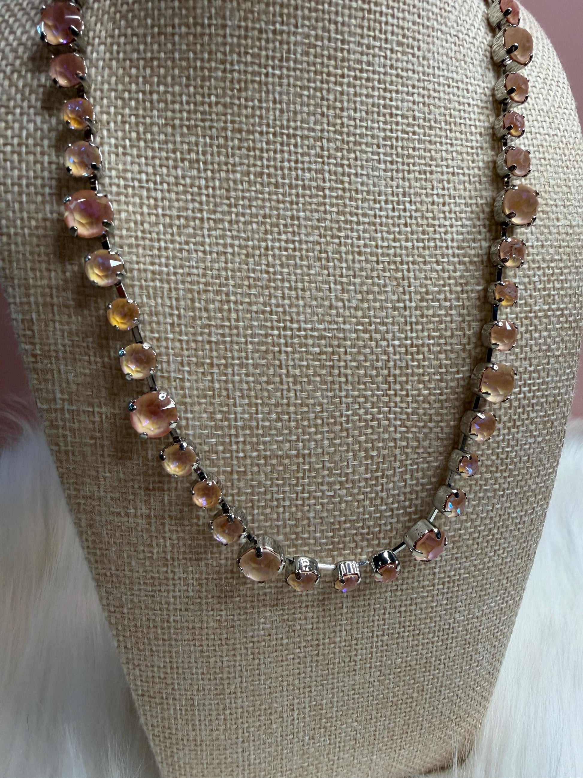 Necklace with aurora crystals on a beige bust