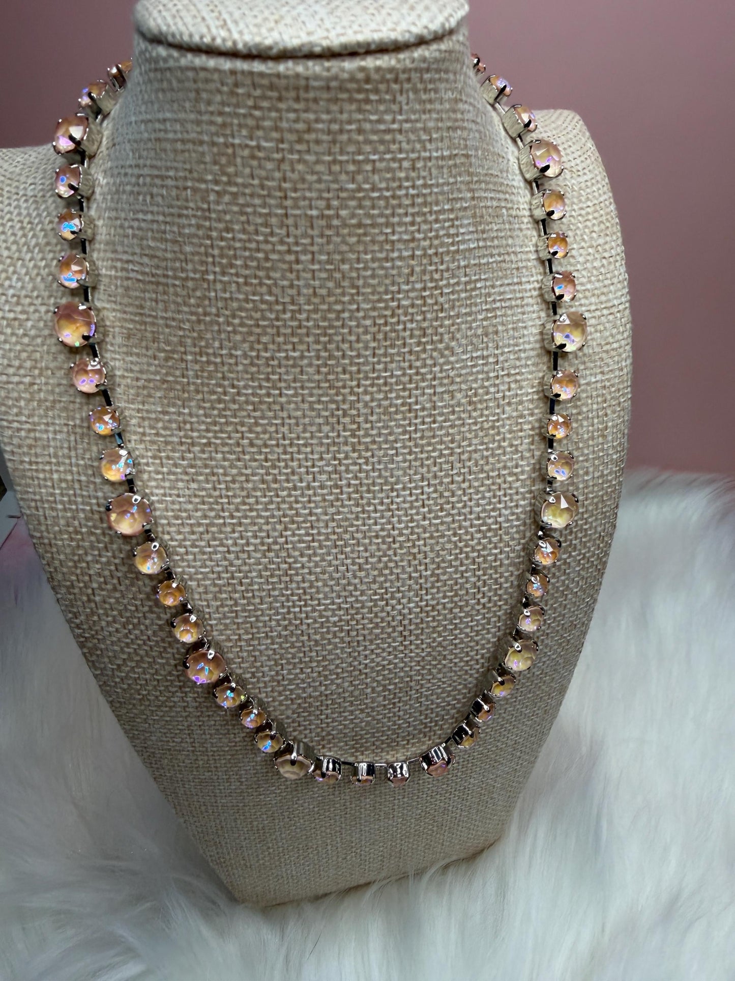 Necklace on a mannequin bust with a soft pink background