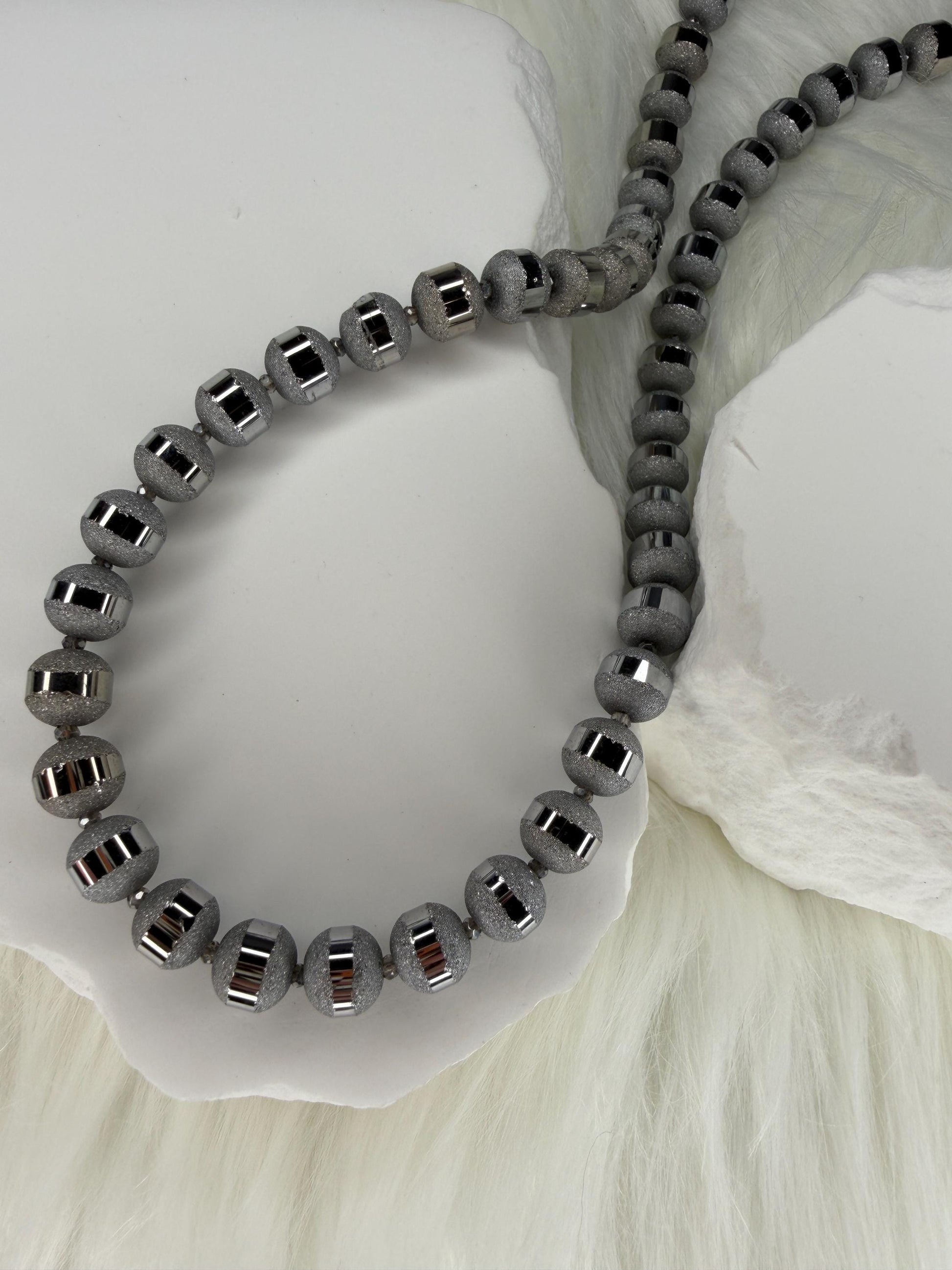Gray beaded bracelet on a white shell