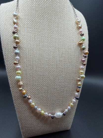 Multicolored pearl necklace on a beige bust against a dark background