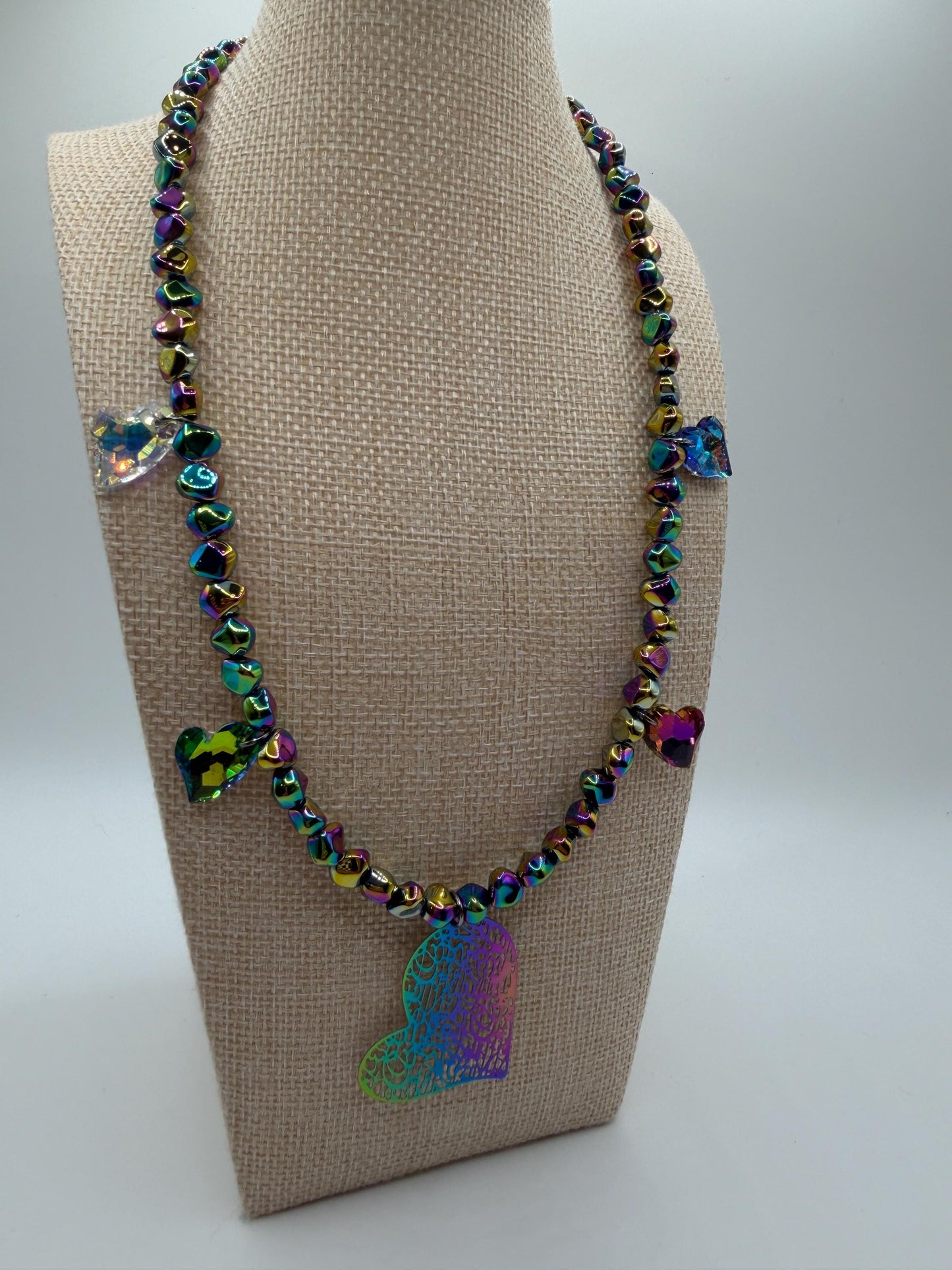 Necklace with colorful butterfly pendants on a beige mannequin bust.