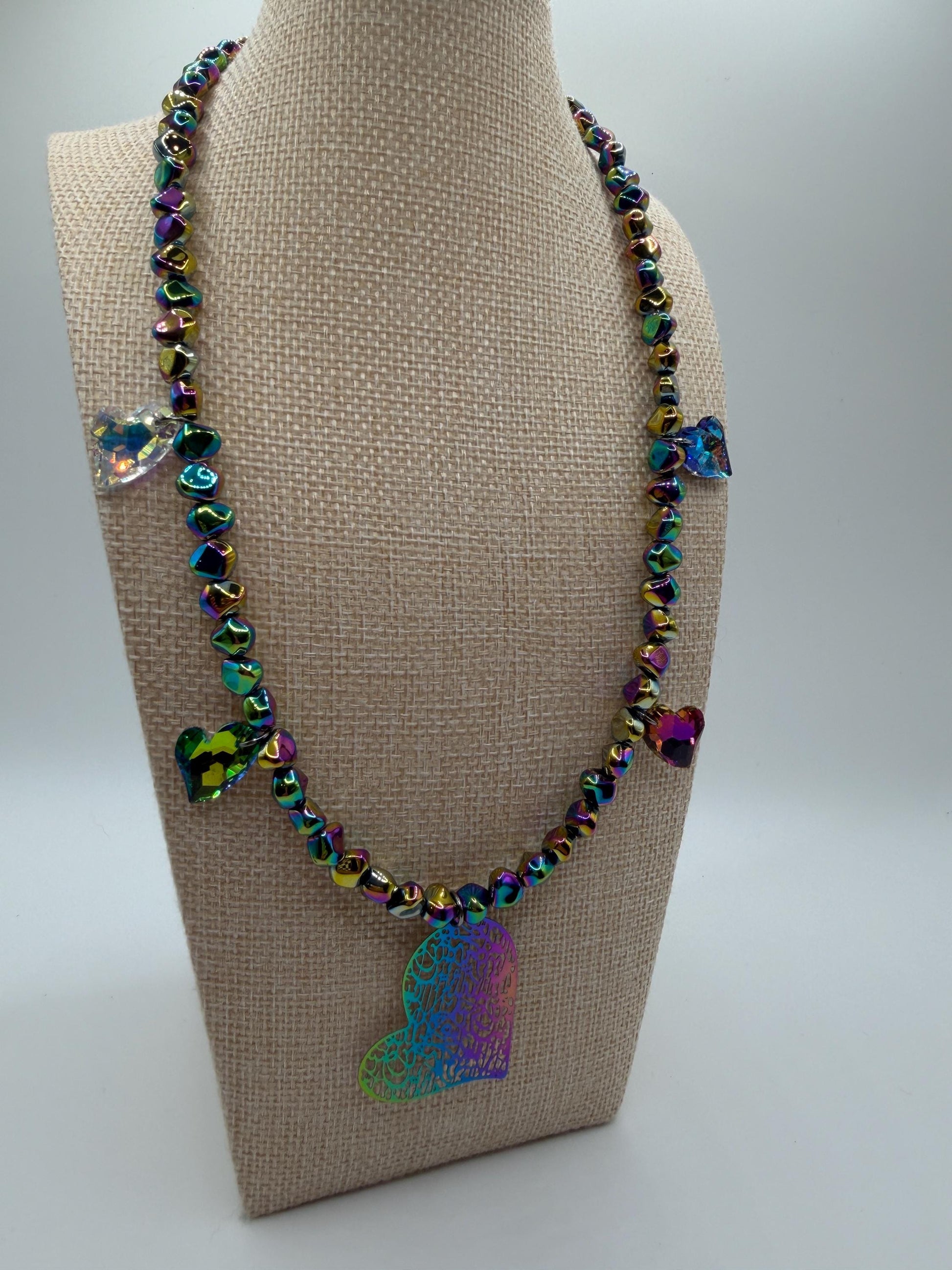 Necklace with colorful butterfly pendants on a beige mannequin bust.