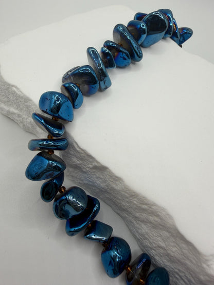 Blue beaded necklace on a white surface
