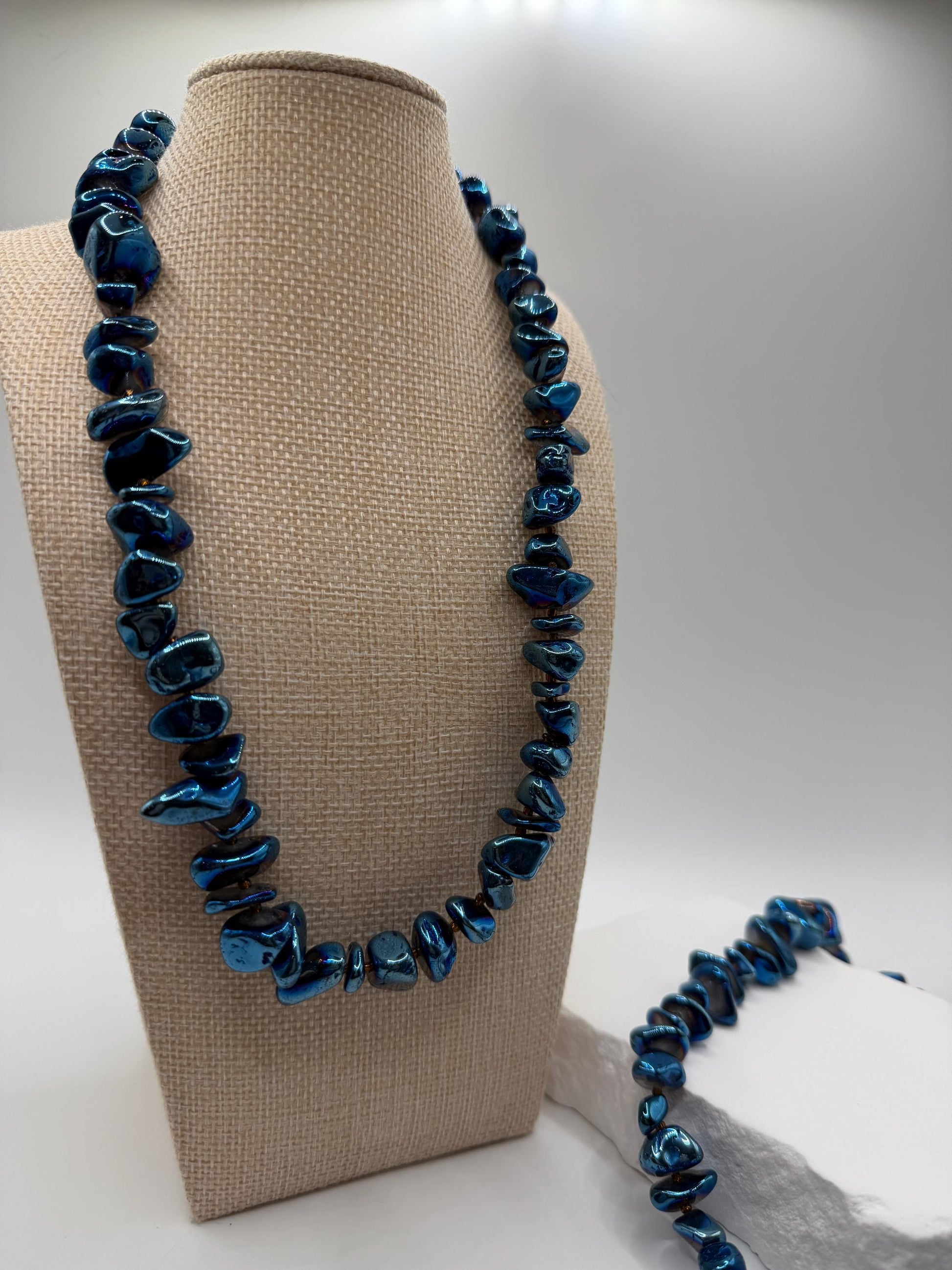 Blue beaded quartz necklace on a mannequin bust with a plain background