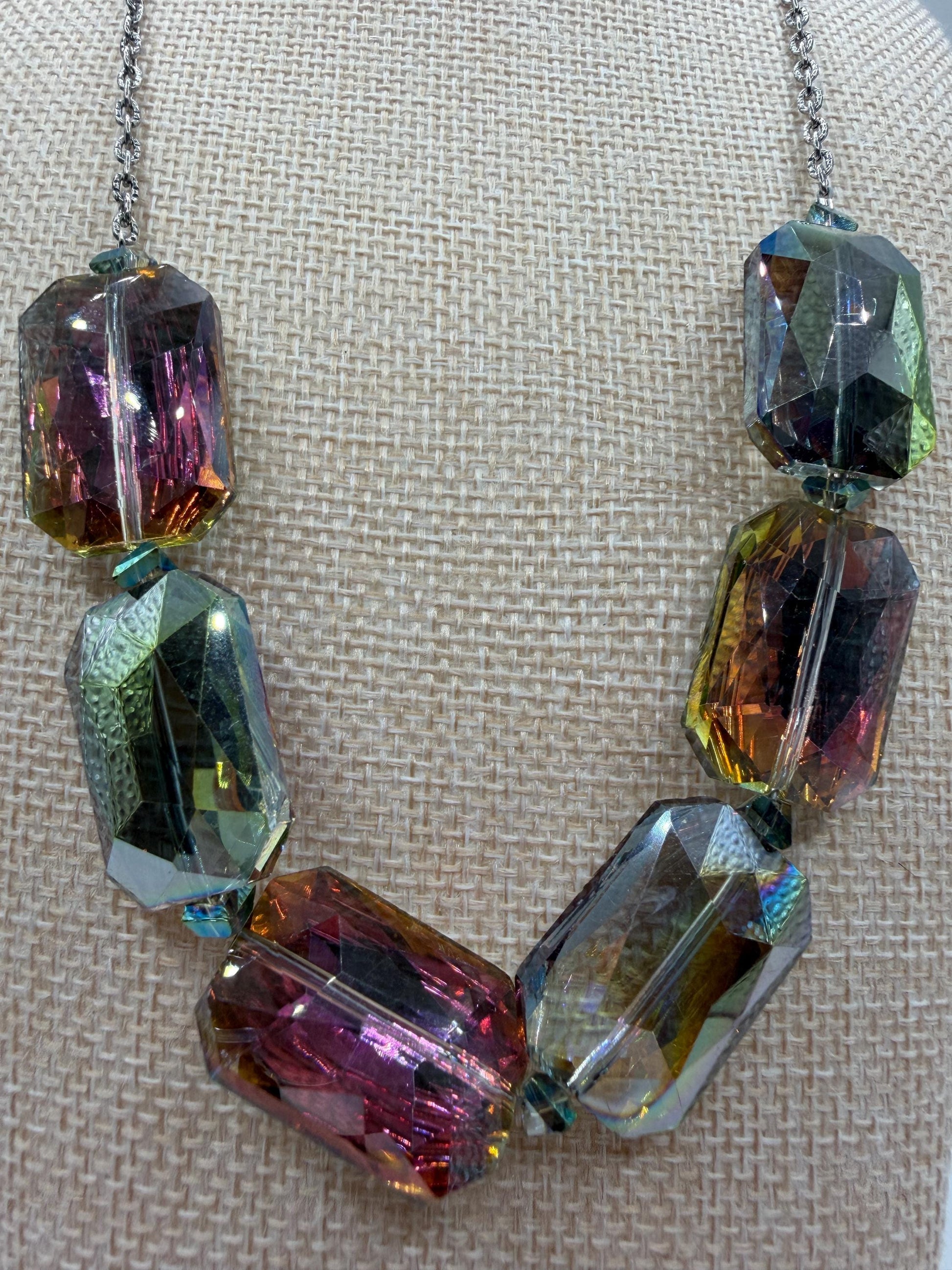 Necklace with multicolored crystal beads on a textured beige background