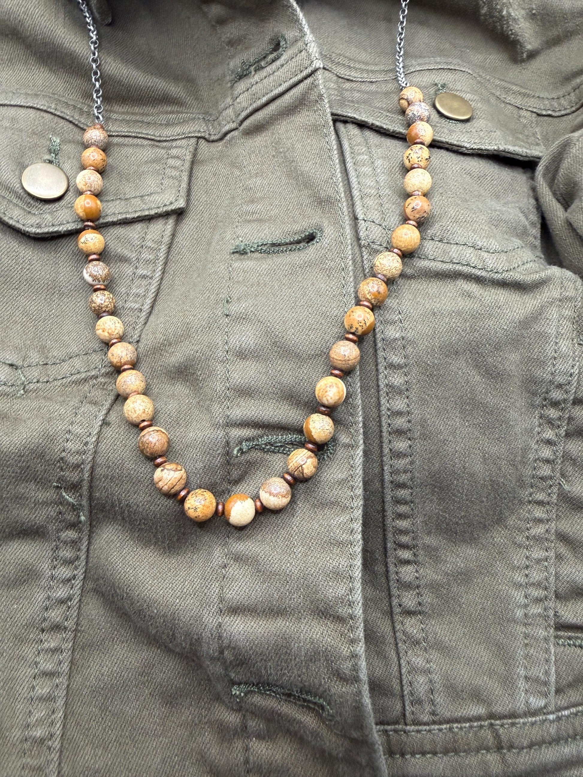 Necklace with brown beads on a green jacket