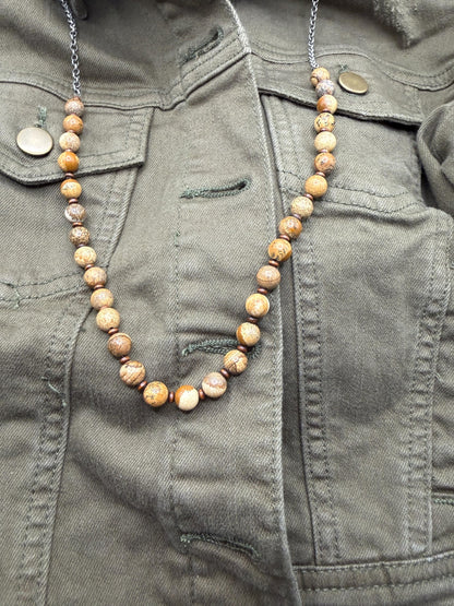 Necklace with brown beads on a green jacket
