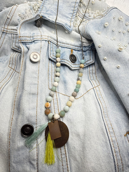 Necklace with beads and tassel on a denim jacket