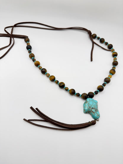 Necklace with beads and a turquoise stone on a white background