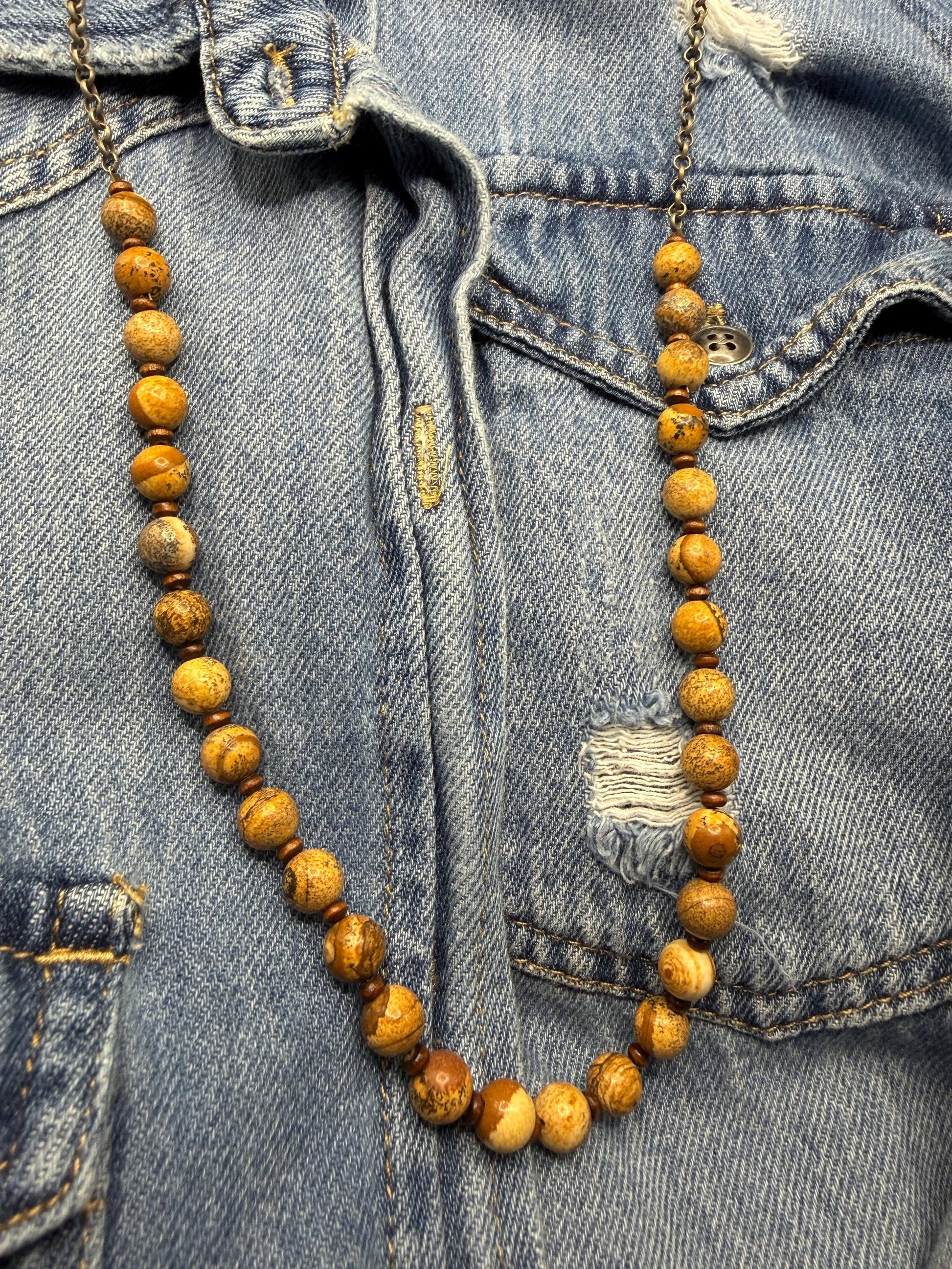 Wooden beaded necklace draped over a denim jacket