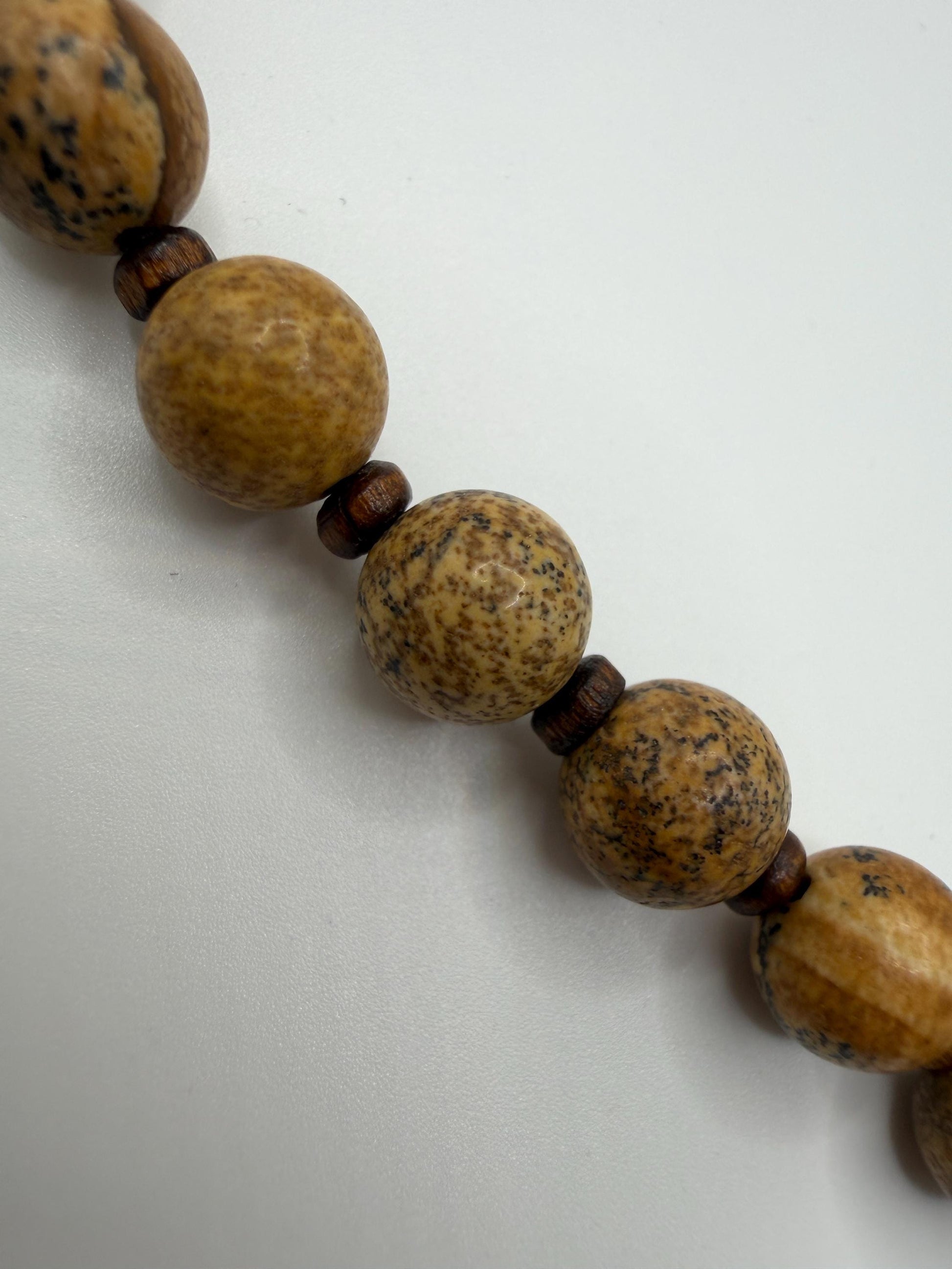 Close-up of a wooden beaded necklace on a white background