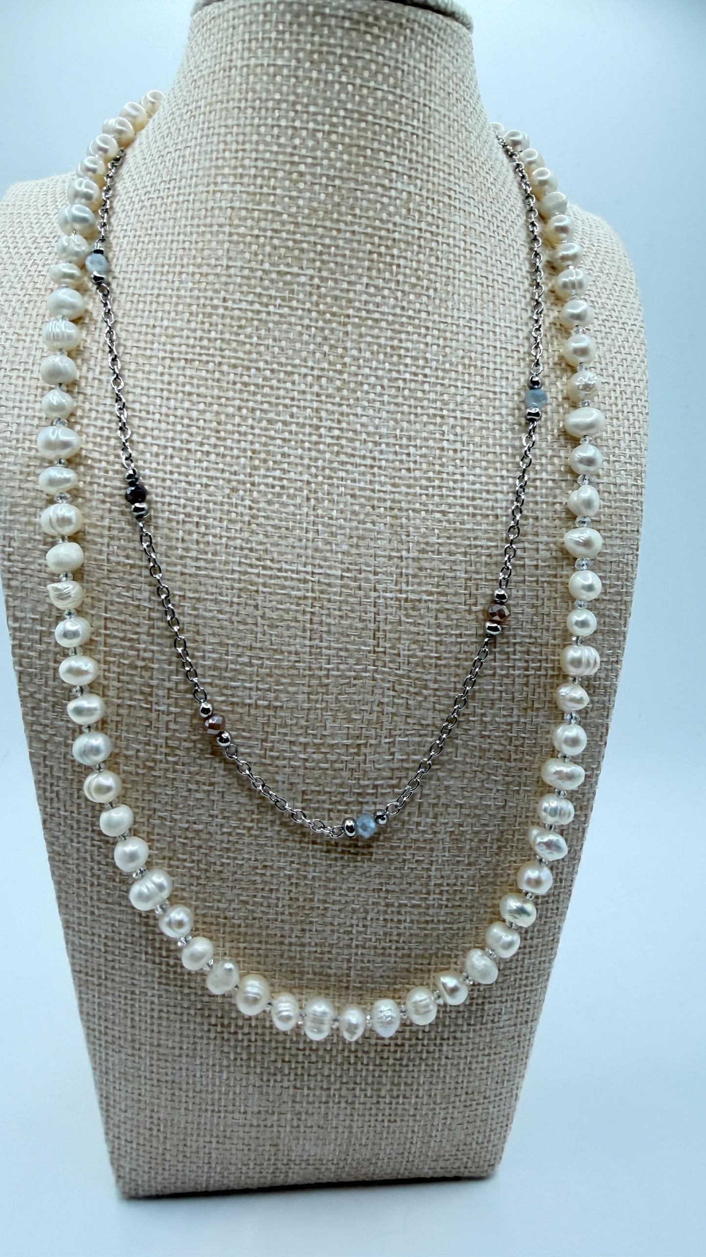 Pearl necklace on a mannequin bust with a plain background
