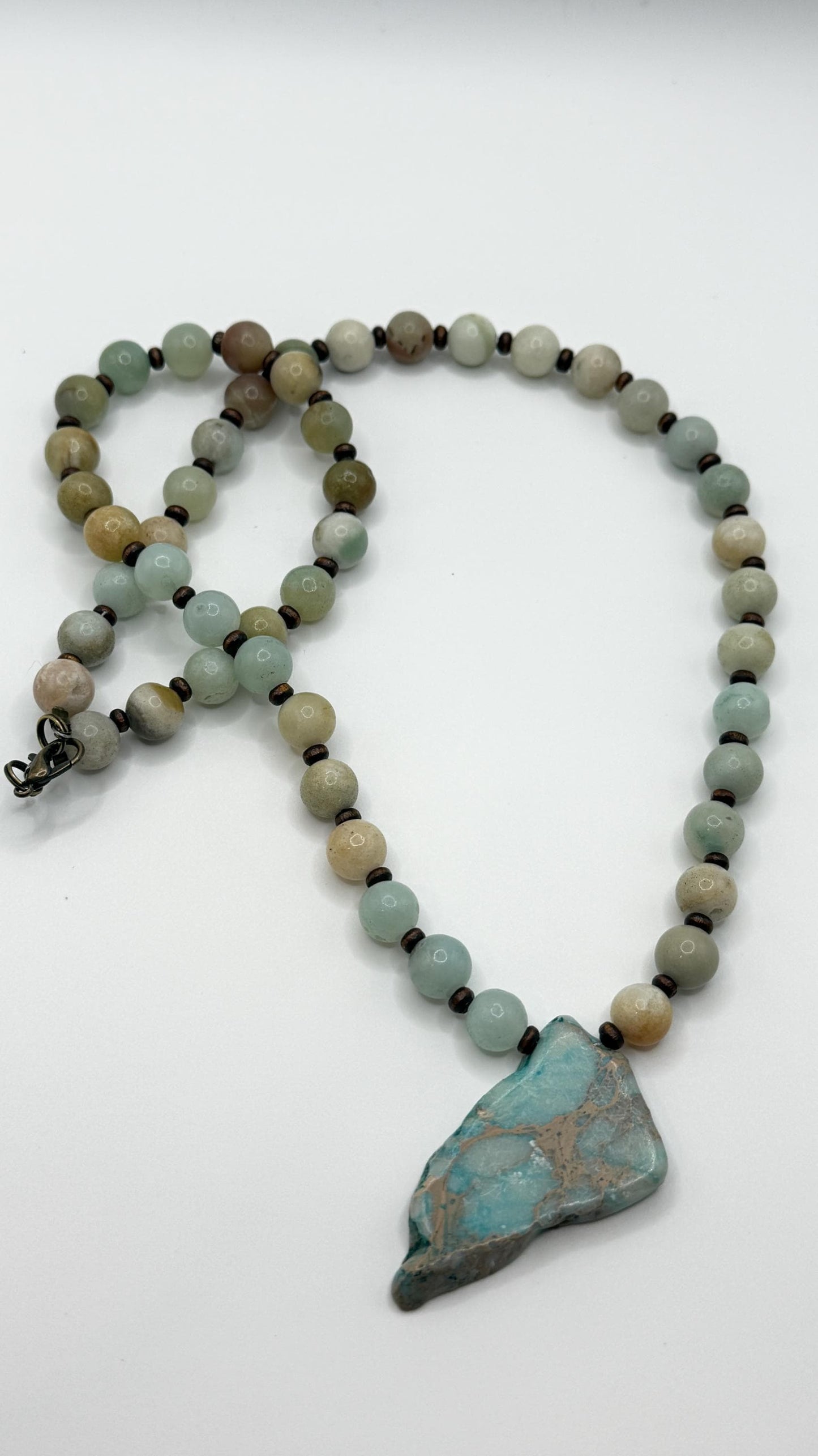 Necklace with beads and a large turquoise stone on a white background