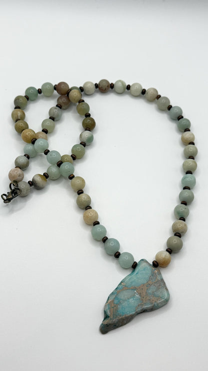 Necklace with beads and a large turquoise stone on a white background