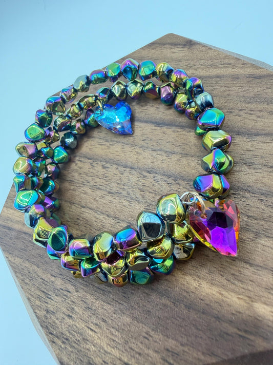 Multicolored beaded bracelet on a wooden block with a light blue background