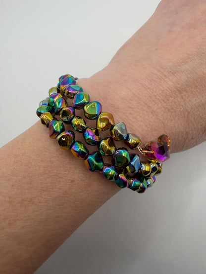 Multicolored beaded bracelet on a wrist against a white background