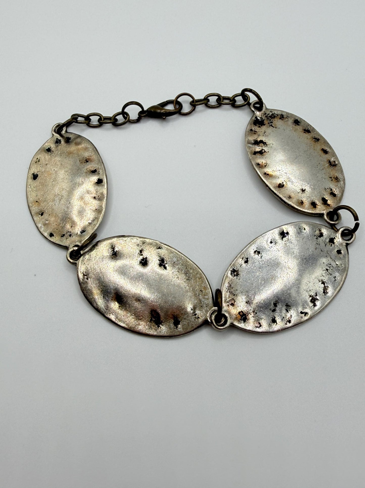 silver and bronze  bracelet with oval pendants on a gray background