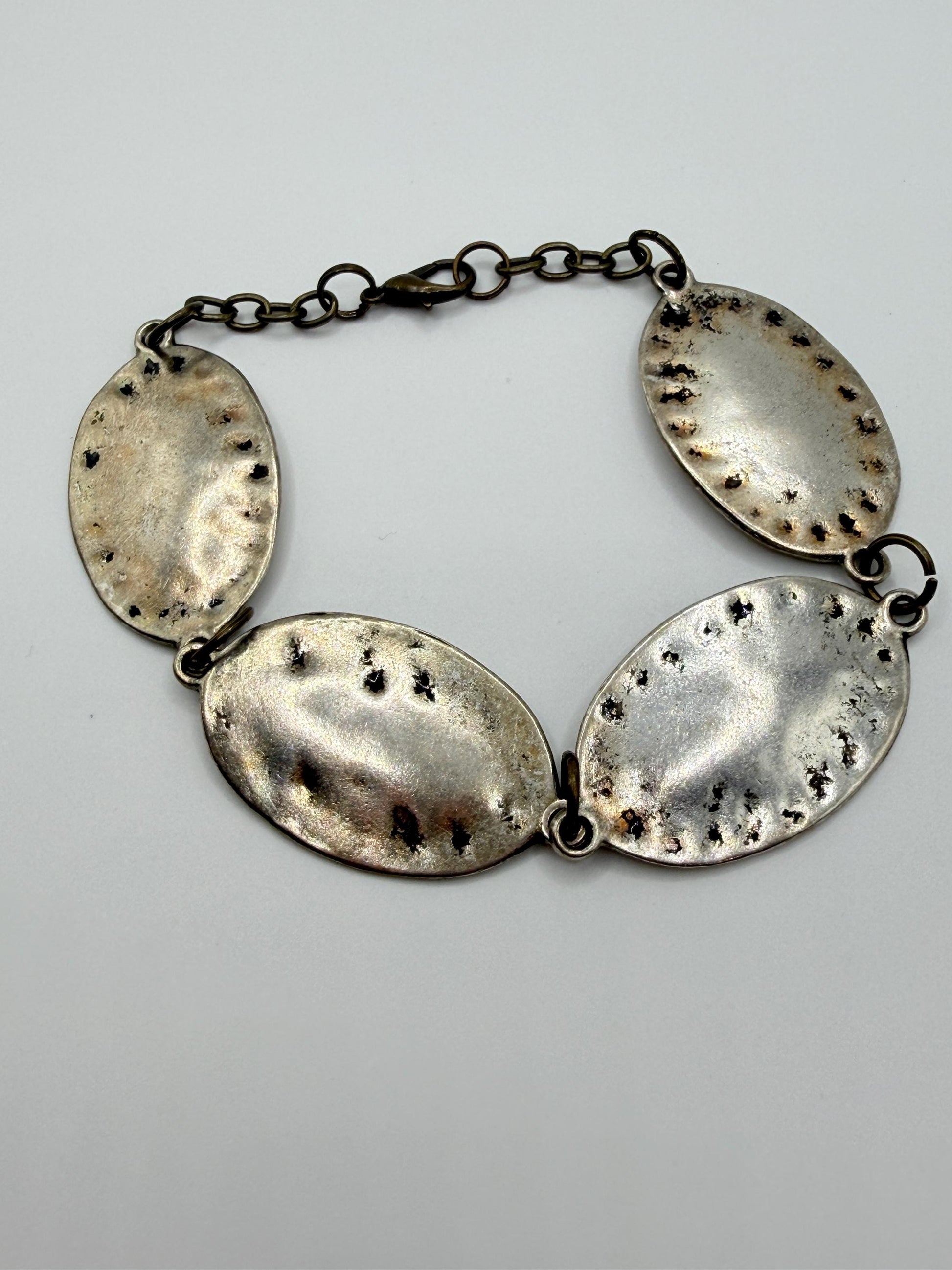 silver and bronze  bracelet with oval pendants on a gray background