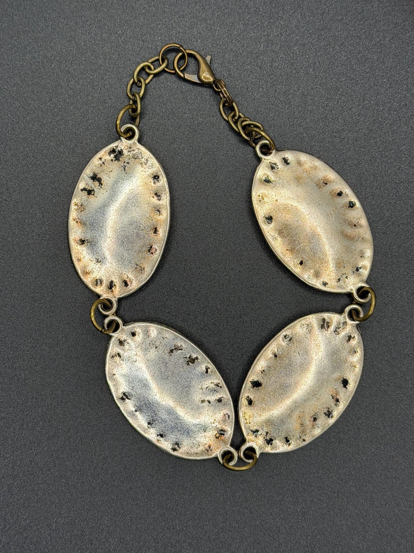 silver and bronze  bracelet with oval-shaped links on a gray background