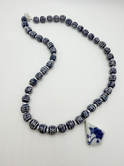 Necklace with blue and white beads and a matching pendant on a white background