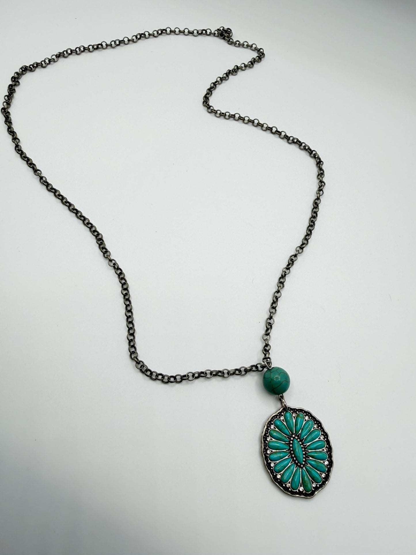 Necklace with a turquoise pendant on a light gray background