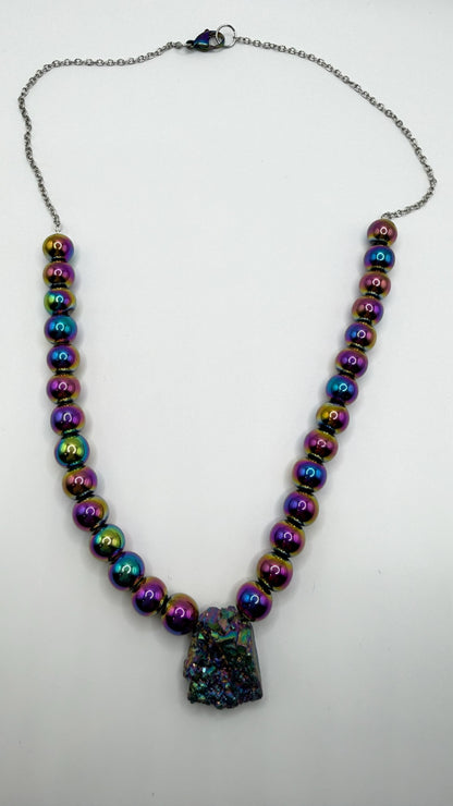 Necklace with multicolored beads and a dark pendant on a white background