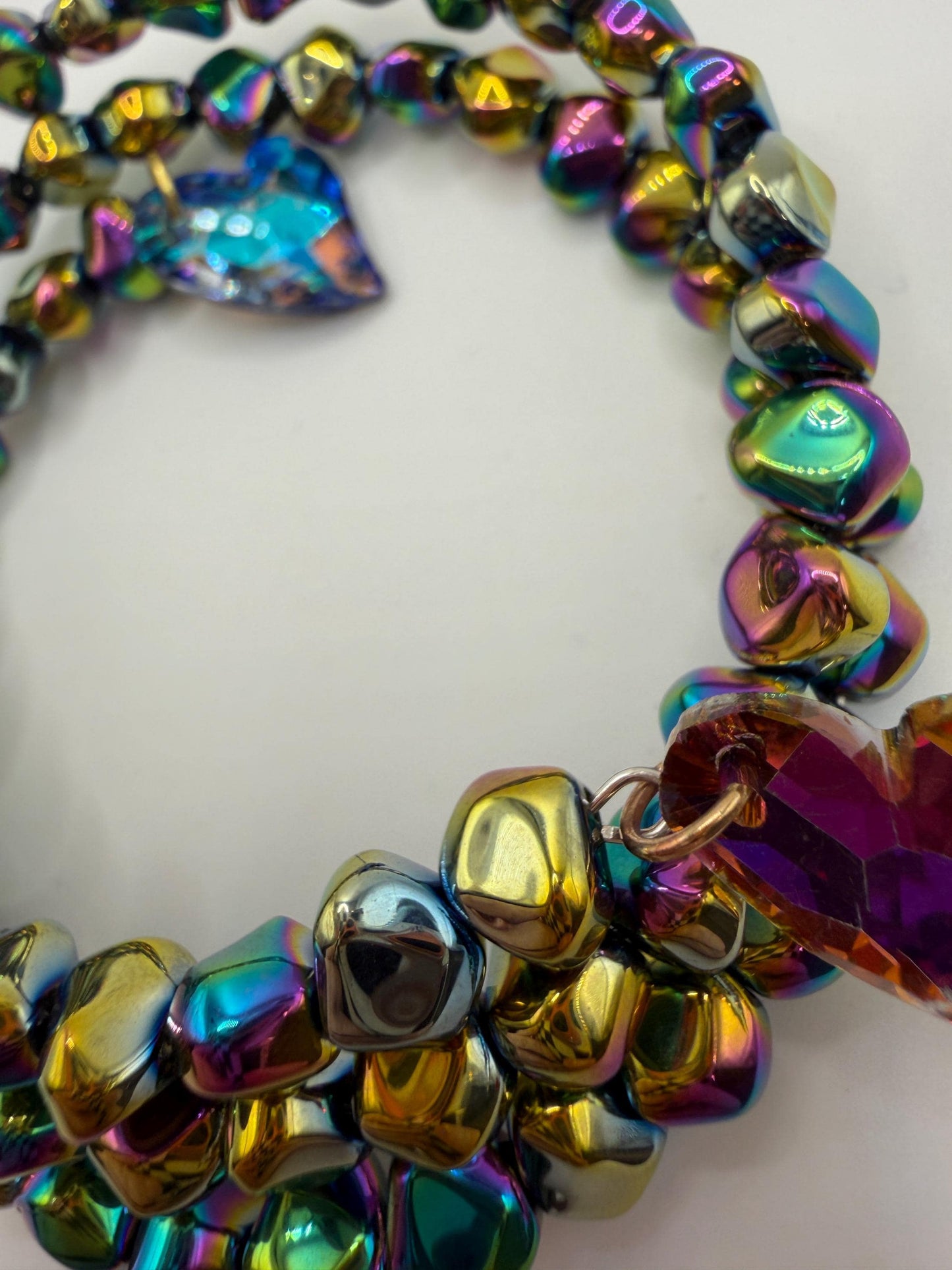 Multicolored beaded bracelet with heart-shaped beads on a white background